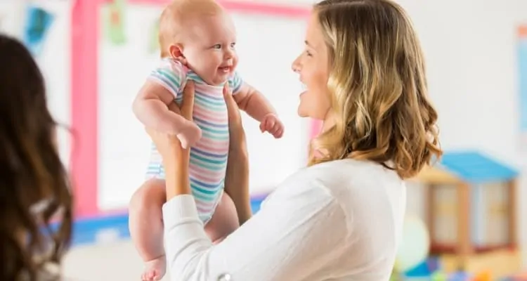 daycare worker holding a baby