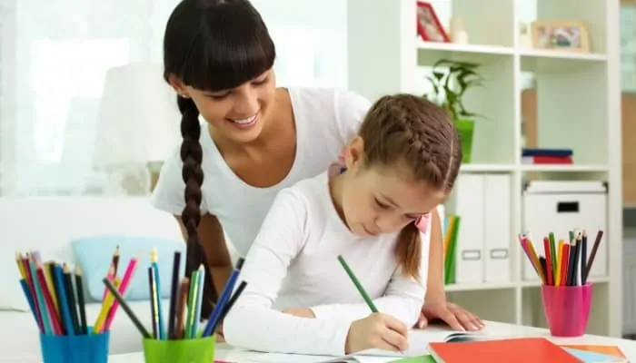 child drawing as adult watches