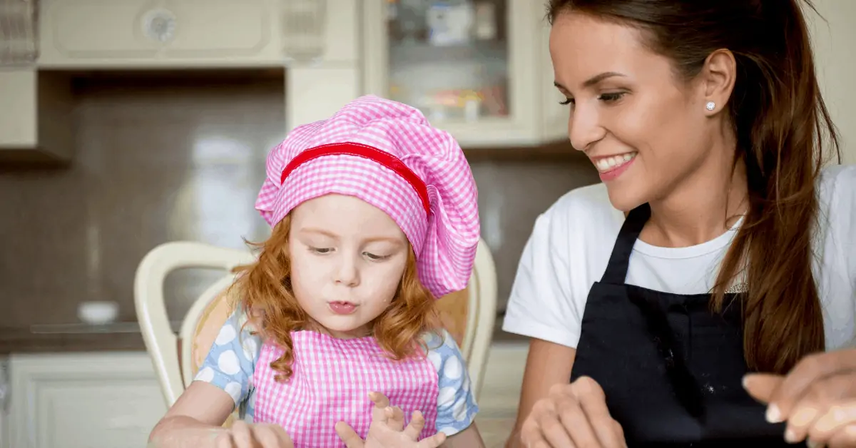 a babysitter watching a kid as they bake cookies