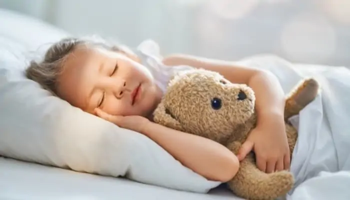 child sleeping with teddy bear