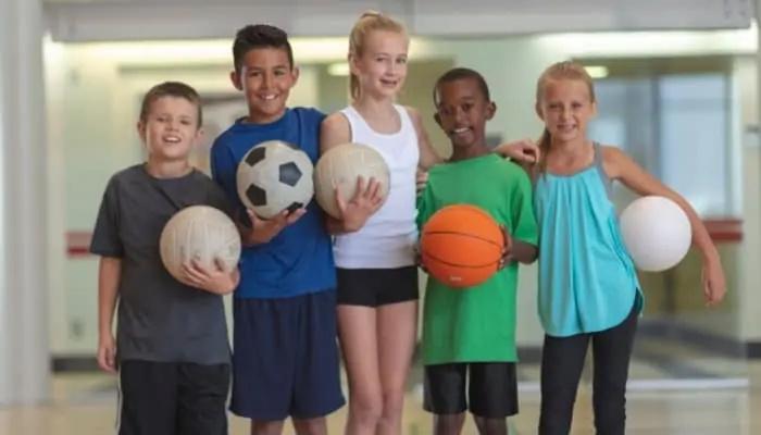 kids holding different types of sports balls