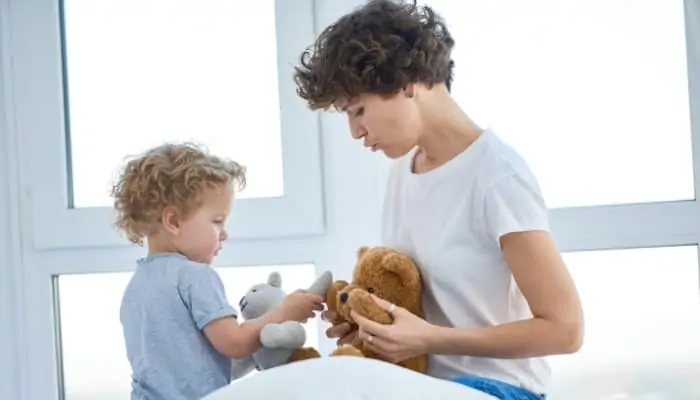 mom playing with teddy bear with child
