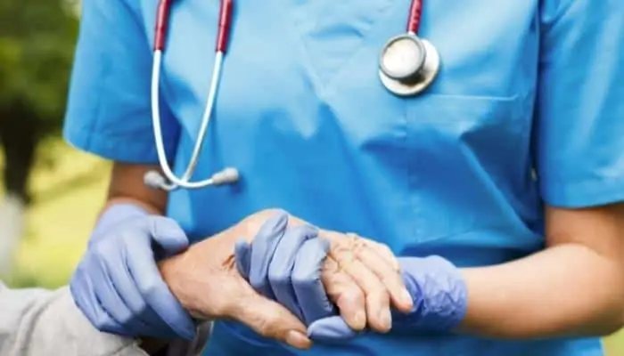 nurse holding elderly patients hand