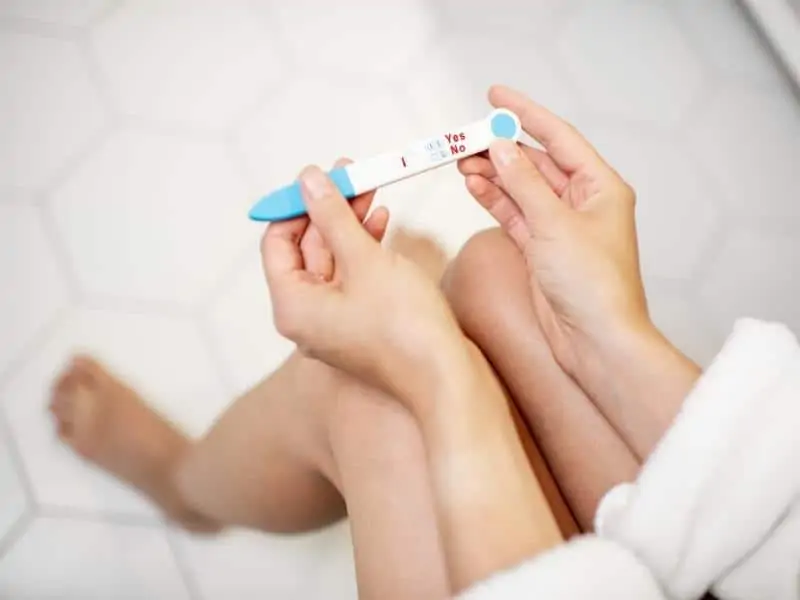 a woman holding a pregnancy test strip