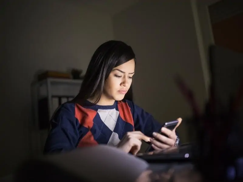 a woman in a dark room on the phone