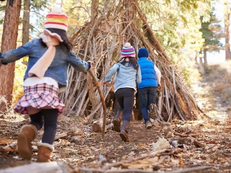 children playing in a twig house