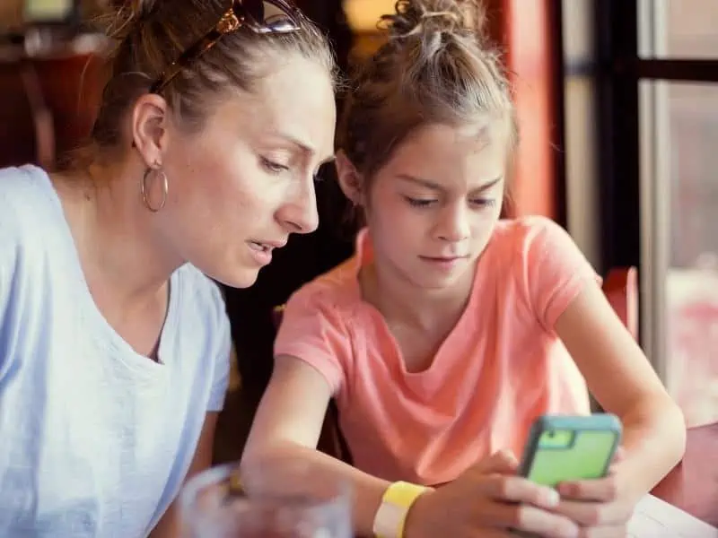 mother watching her daughter use her phone