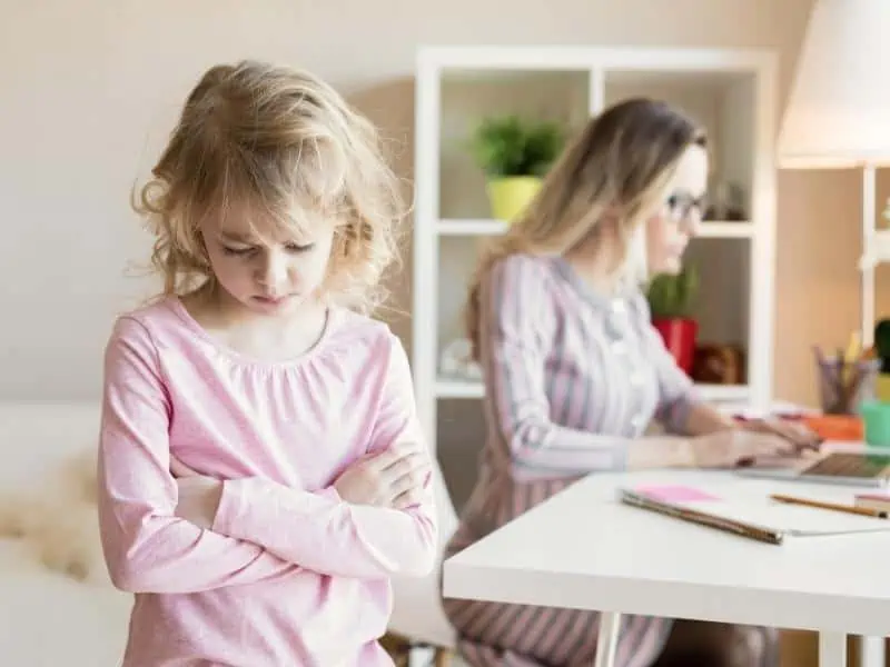 sad kid with mom with her laptop