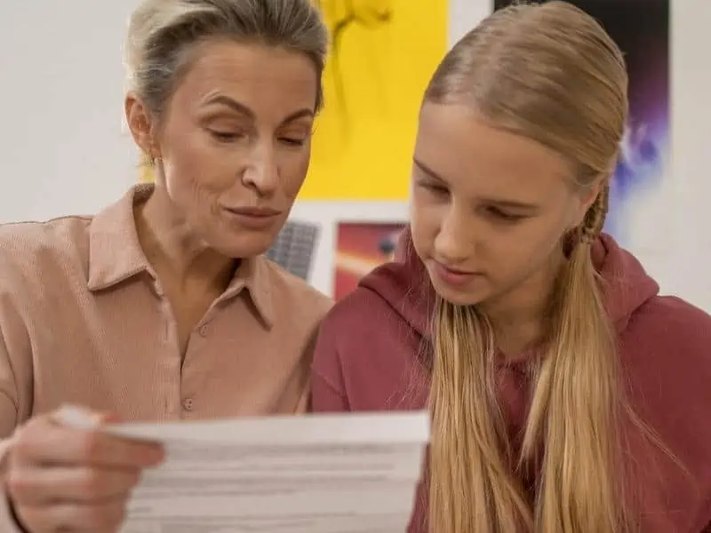 mother and daughter looking at the paper