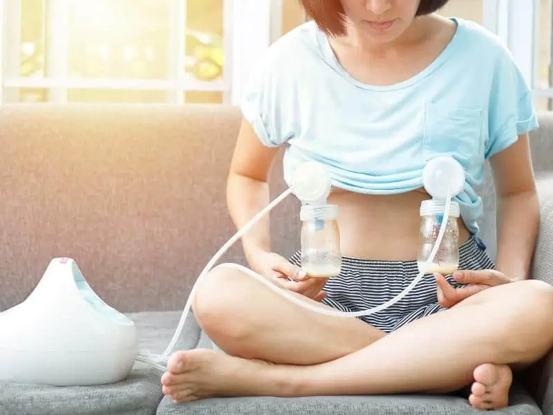 woman sitting with 2 pumping bottles