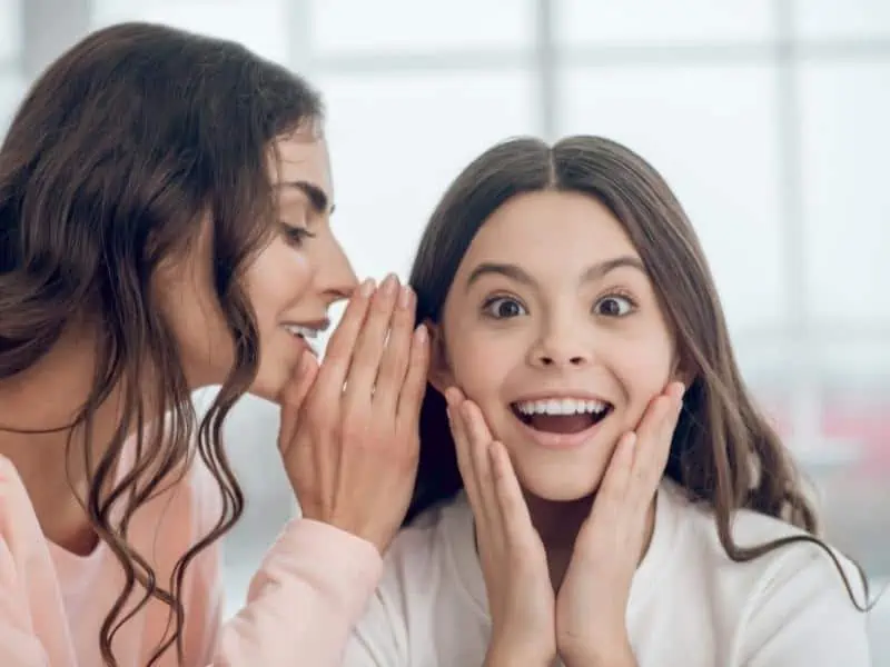 mom whispering to daughter