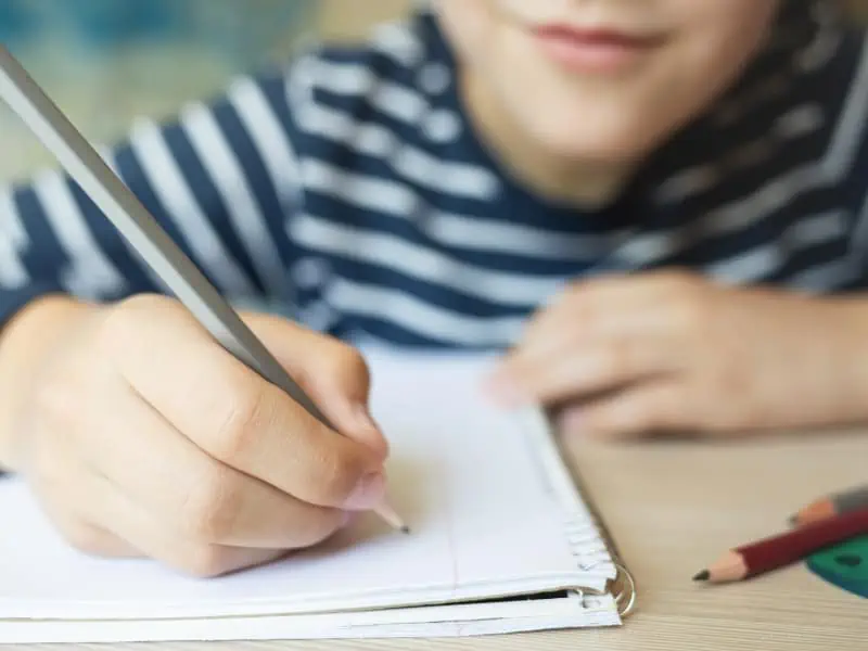 kid holding pencil